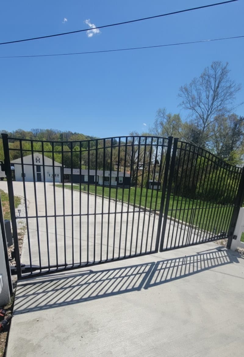 Black aluminum arched estate gate with decorative design