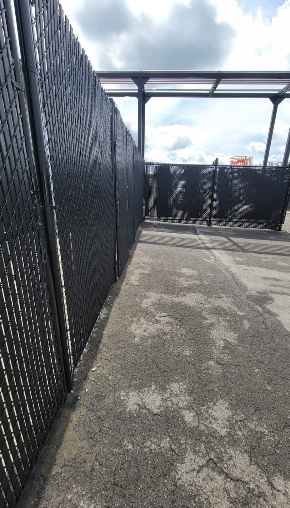 Black chain link fence with privacy slats in commercial setting